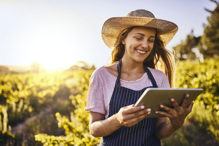 agricultora sorrindo olhando seu tablet