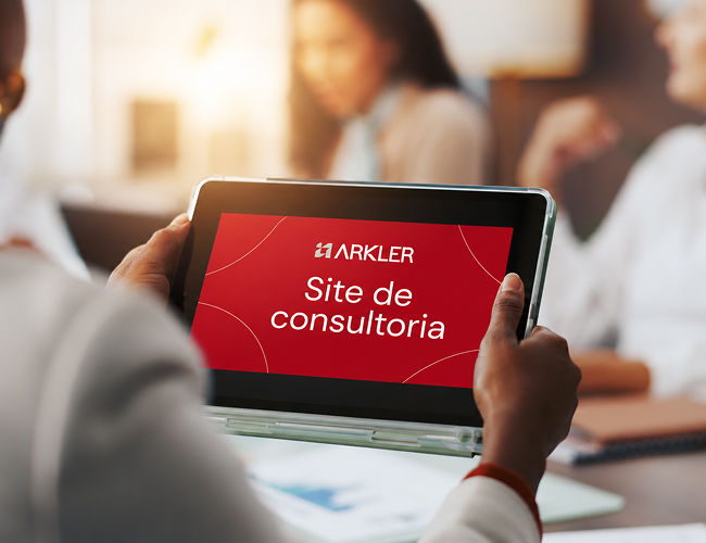 Pessoa segurando tablet com marca vermelha da Arkler com o escrito "Site de Consultoria"