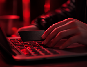mão masculina mexendo no teclado de notebook com luz vermelha
